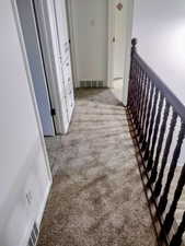 Hall with light carpet and an upstairs landing