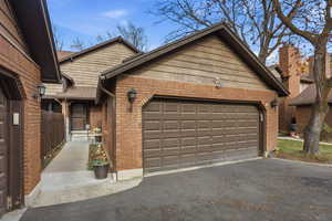 View of front facade featuring brick siding and asphalt driveway
