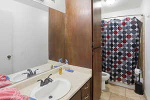 Full bathroom with curtained shower and vanity