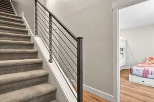 Staircase featuring baseboards and wood finished floors