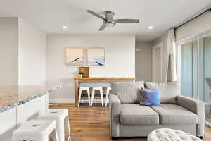 Living area with recessed lighting, light wood-type flooring, and a ceiling fan