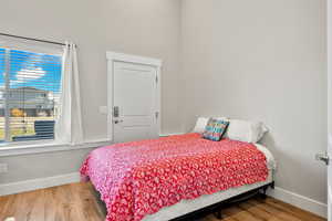 Bedroom with wood finished floors and baseboards