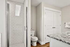 Bathroom featuring vanity, a shower stall, and dark wood-style floors