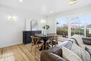 Dining space with healthy amount of natural light, light wood-style floors, recessed lighting, and a chandelier