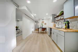 Corridor with light wood-type flooring, recessed lighting, and wine cooler