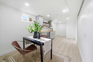 Office space with a bar, recessed lighting, light wood-type flooring, and beverage cooler