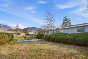 View of yard featuring a mountain view, a patio, and a fire pit
