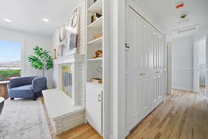 Corridor featuring plenty of natural light, light wood-style floors, and recessed lighting