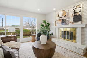 Living area with a brick fireplace and recessed lighting