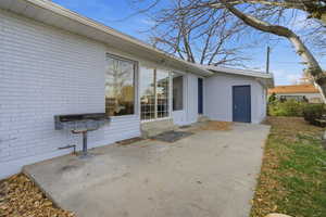 View of side of property with brick siding and a patio area