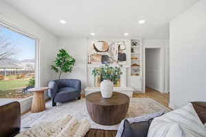 Sitting room featuring recessed lighting, light wood-style flooring, built in features, and a brick fireplace
