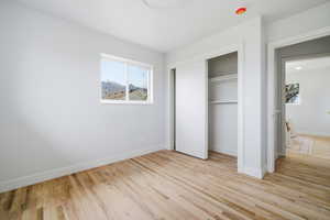 Unfurnished bedroom with light wood finished floors and a closet
