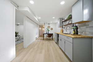 Corridor featuring light wood-type flooring, recessed lighting, and beverage cooler