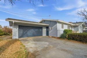 View of front of house featuring brick siding, concrete driveway, and a garage