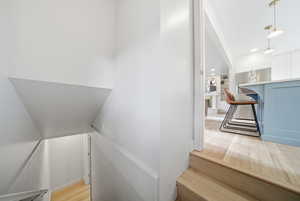 Stairway featuring wood finished floors and recessed lighting