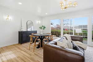 Dining room featuring light wood-style flooring, a chandelier, and recessed lighting