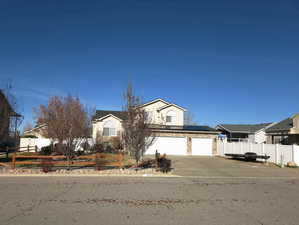 View of front of property with roof mounted solar panels and concrete driveway