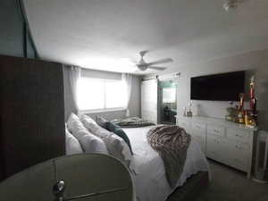 Bedroom featuring a barn door and a ceiling fan