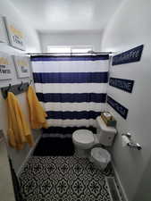Full bath featuring a shower with shower curtain and tile patterned flooring