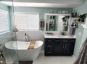 Full bathroom with a soaking tub, vanity, and light tile patterned flooring