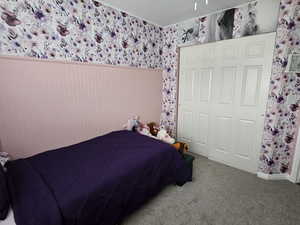 Carpeted bedroom featuring wallpapered walls