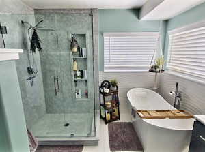 Full bathroom with a freestanding bath, a shower stall, vanity, and tile patterned floors