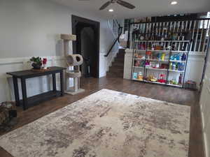 Living area featuring stairs, dark wood-style flooring, ceiling fan, and recessed lighting