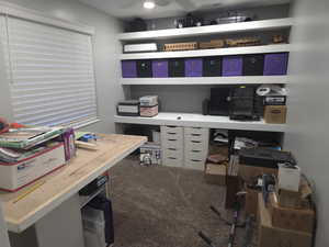 Home office featuring dark colored carpet