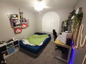 Bedroom featuring dark colored carpet