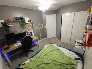 Bedroom with an office area, carpet floors, and a closet