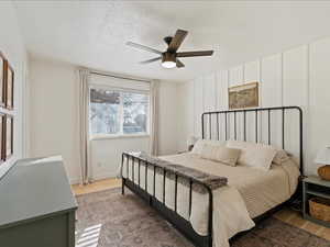 Bedroom featuring a ceiling fan, wood finished floors, and a textured ceiling