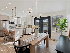 Dining space featuring vaulted ceiling, recessed lighting, and light wood-style flooring