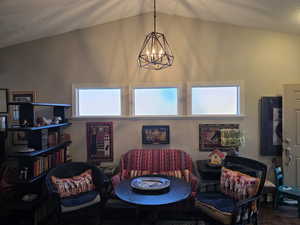 Dining room featuring a chandelier, a textured ceiling, and vaulted ceiling
