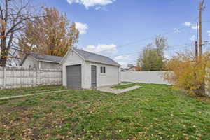 Fenced backyard with an outdoor structure and a detached garage