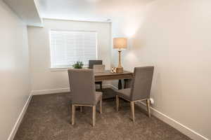 Office featuring dark colored carpet and baseboards