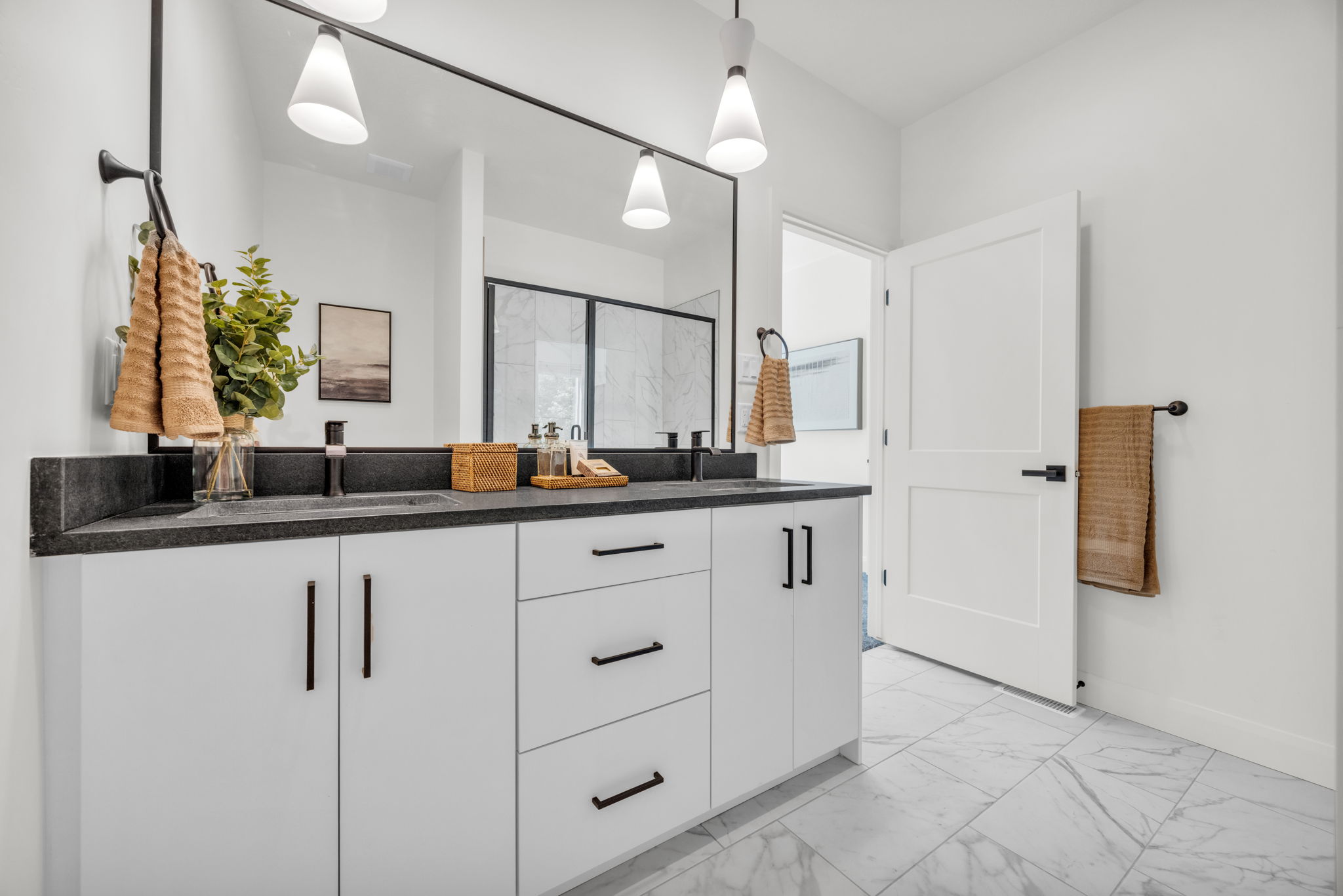 Full bath featuring light marble finish flooring, double vanity, and a marble finish shower