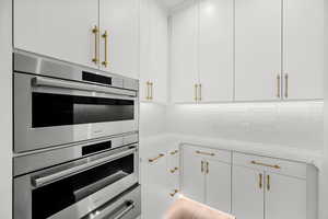 A spacious bonus pantry featuring two Wolf convection steam ovens, a warming drawer, and abundant cabinetry for effortless organization and culinary convenience.