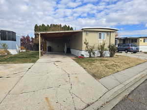 Manufactured / mobile home with concrete driveway and a carport