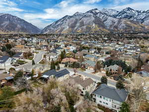 Aerial view of property and surrounding area featuring a mountain backdrop and nearby suburban area