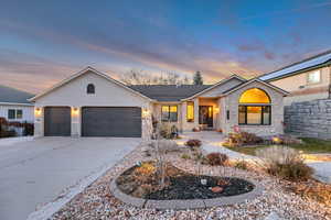 Single story home featuring stone siding, driveway, a garage, and stucco siding