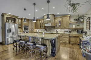 Kitchen with open shelves, glass insert cabinets, vaulted ceiling, appliances with stainless steel finishes, and light wood-type flooring