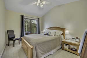 Bedroom featuring vaulted ceiling, light colored carpet, and a ceiling fan
