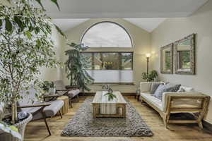 Sitting room with vaulted ceiling and light wood-type flooring