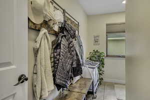 Mudroom with light tile patterned floors and baseboards