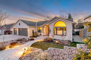 Ranch-style house with concrete driveway, stone siding, a garage, stucco siding, and roof with shingles