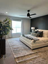 Bedroom with carpet, a ceiling fan, and a textured ceiling