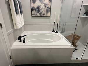 Full bath featuring a bath and a shower stall