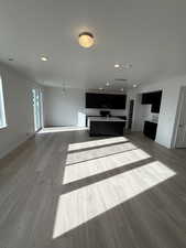 Unfurnished living room featuring recessed lighting, dark wood finished floors, and a textured ceiling