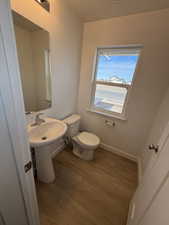 Half bath featuring light wood finished floors and a textured ceiling