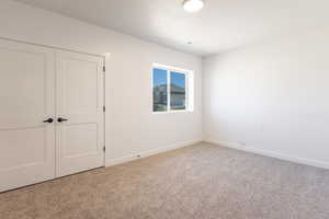 Unfurnished bedroom with a closet and carpet floors